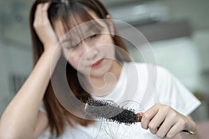 Asian woman have problem with long hair loss attach to comb brush