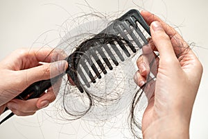 Asian woman have problem with long hair loss attach to comb brush