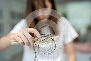 Asian woman have problem with long hair loss attach to comb brush