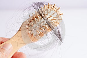 Asian woman have problem with long hair loss attach to comb brush