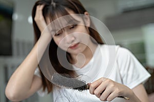 Asian woman have problem with long hair loss attach to comb brush