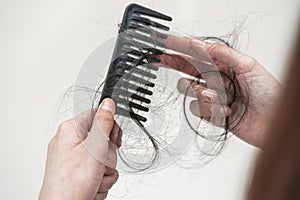 Asian woman have problem with long hair loss attach to comb brush