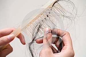 Asian woman have problem with long hair loss attach to comb brush