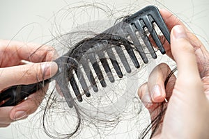 Asian woman have problem with long hair loss attach to comb brush