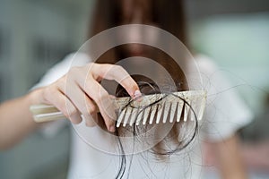 Asian woman have problem with long hair loss attach to comb brush