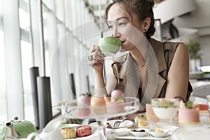 Asian woman having afternoon tea in luxurious hotel