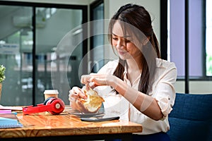 Asian woman having breakfast at her office room.