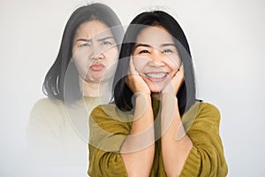 Asian woman having double personality ,mood swings or bipolar disorder with different emotions moody, happy face