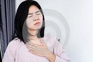 Asian woman having heart attack, chest pain, difficulty to breathe