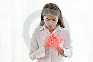 Asian woman having heart attack while hands touching her chest, Healthcare and medical concept