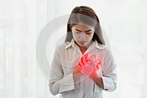 Asian woman having heart attack while hands touching her chest, Healthcare and medical concept