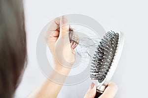 Asian woman having problem with hair loss on comb