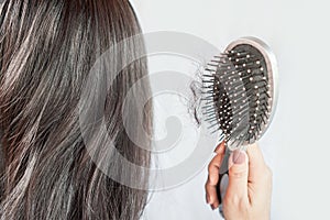 Asian woman having problem with hair loss on comb