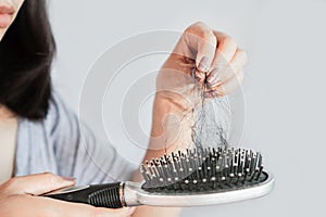 Asian woman having problem with hair loss on comb