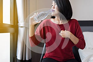 Asian woman having or symptomatic reflux acids,Gastroesophageal reflux disease,Drinking water