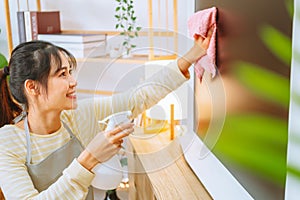 Asian woman with headache doing spring cleaning chores in her living room at home overworked housekeeping service