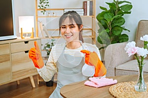 Asian woman with headache doing spring cleaning chores in her living room at home overworked housekeeping service