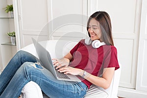 Asian woman with headphone using laptop computer with relax pose