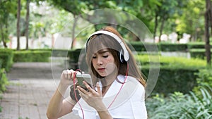 asian woman with headphones. young female holding mobile smart