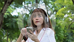 Asian woman with headphones. young female holding mobile smart