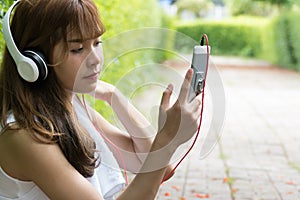 Asian woman with headphones. young female holding mobile smart
