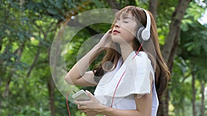 Asian woman with headphones. young female holding mobile smart