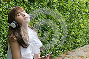 Asian woman with headphones. young female holding mobile smart