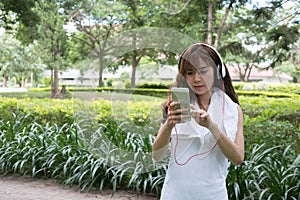 Asian woman with headphones. young female holding mobile smart