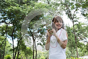 asian woman with headphones. young female holding mobile smart