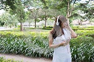 asian woman with headphones. young female holding mobile smart