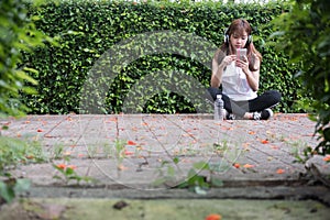 Asian woman with headphones. young female holding mobile smart