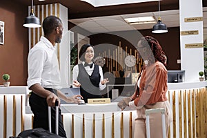 Asian woman helping guests to check in