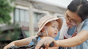 Asian woman and her toddler son riding the bicycle