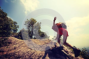 asian woman hiker climbing rock on mountain peak cliff