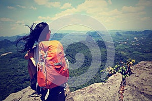 Asian woman hiker enjoy the view on mountain peak cliff