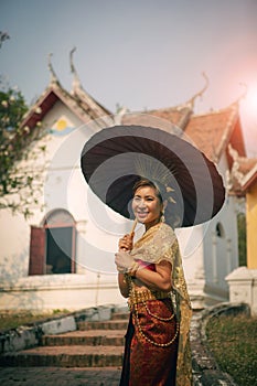 asian woman holding bamboo umbrella standing infront of old temle in ayutthaya world heritage site of unesco thailand photo