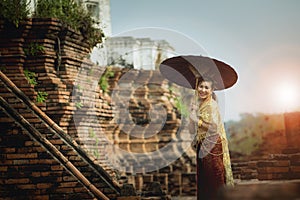 asian woman holding bamboo umbrella standing at old temple of ayutthaya world heritage site of unesco central of thailand