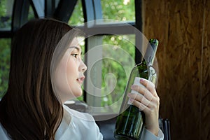 Asian woman holding a bottle of wine/Woman selecting a bottle of wine