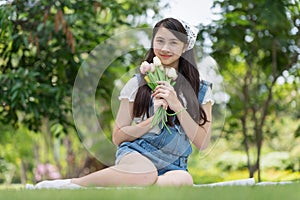 Asian woman holding a bunch of flowers in the park