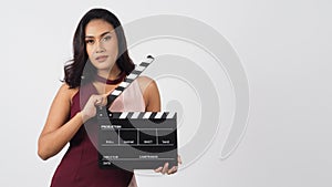 Asian woman is holding clapper board or movie slate use in video production ,film, cinema ,movies industry on white background