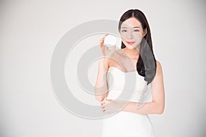 Asian woman holding cosmetics makeup product isolated on white b