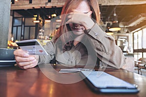 An Asian woman holding credit card with feeling stressed and broke