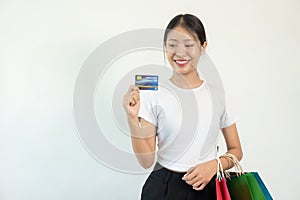 Asian woman holding credit card and shopping bag white background Online banking transaction concept in online shopping