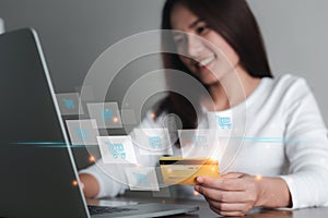 Asian woman holding credit card and using laptop computer with icon shopping cart, Online shopping, e-commerce, internet banking,