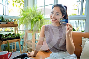 Asian woman is holding credit card and using smartphone shopping online at home. Online shopping  e-commerce  internet banking