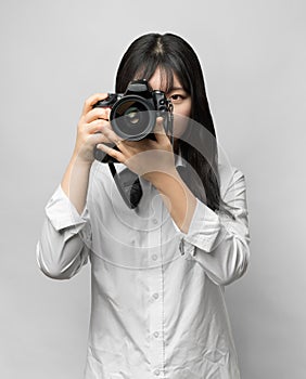 Asian woman holding DSLR camera.
