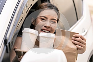 Asian woman holding food bag from drive thru service restaurant