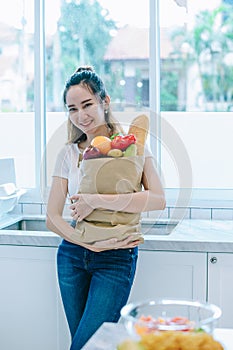 Asian woman holding the fruits in paper bag