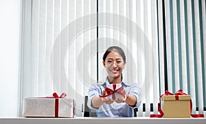 Asian woman holding a gift box Glad to be the giver of surprise with excitement, joy and smiles on the holidays, Christmas,