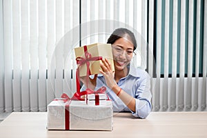 Asian woman holding a gift box Glad to be the giver of surprise with excitement, joy and smiles on the holidays, Christmas,